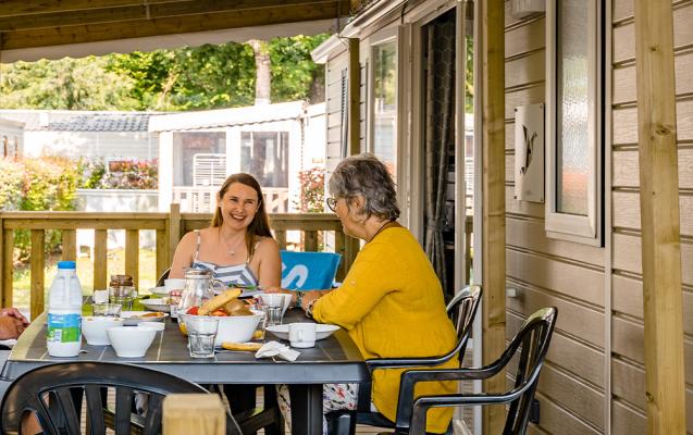 Famille sur la terrasse de son mobil home camping La Réserve